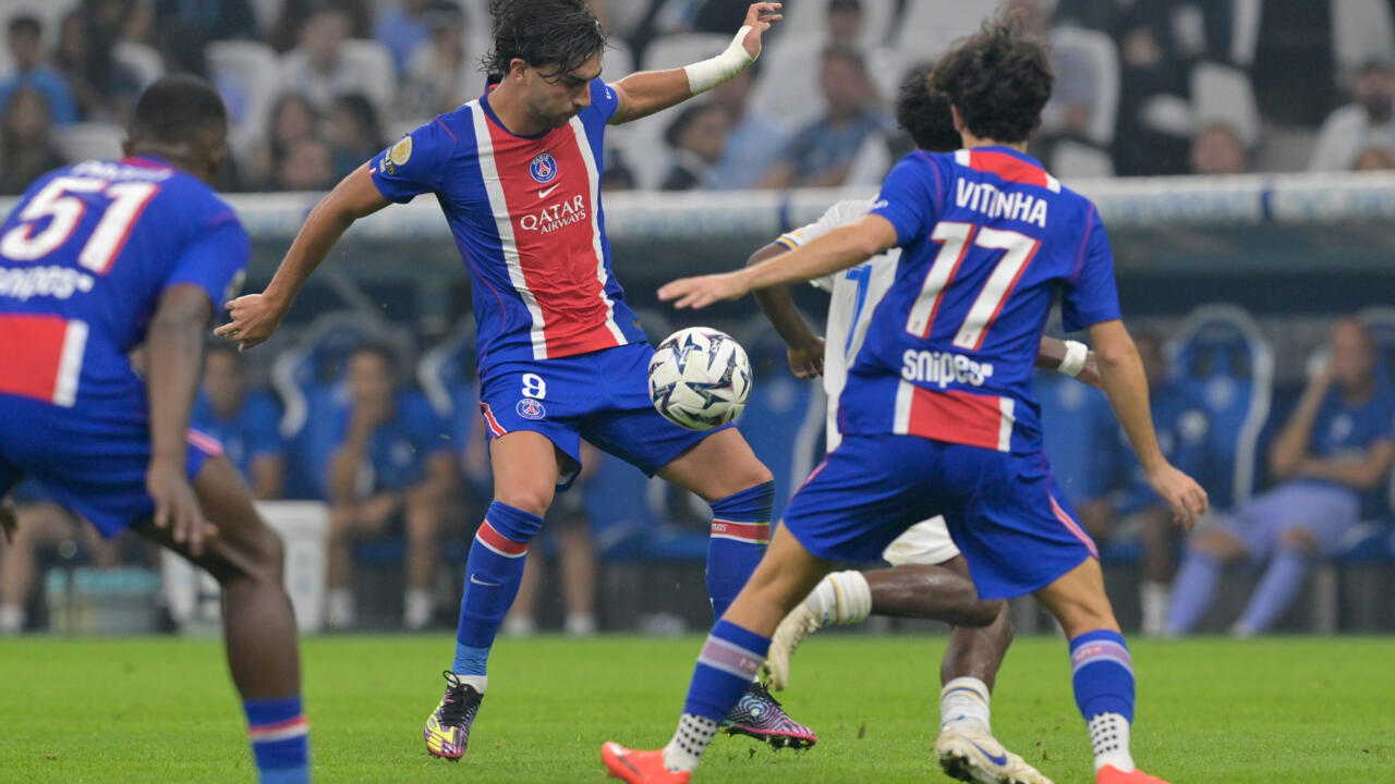 PSG players in blue, red and white contest the ball during a football match