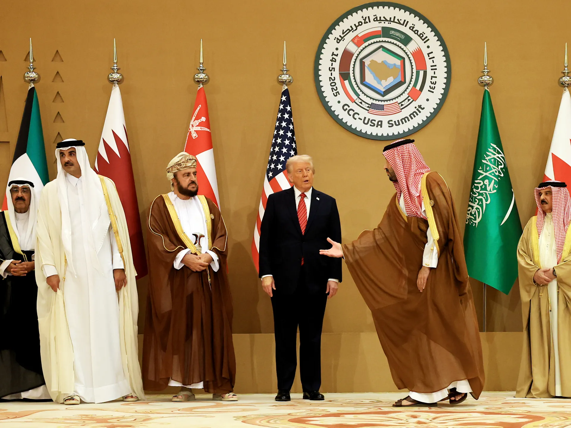 U.S. President Donald Trump stands with Gulf leaders beneath a GCC-US Summit emblem.