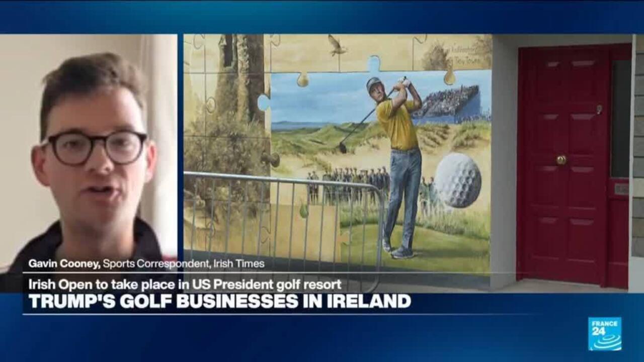 Television interview image showing a man beside a mural and headline about Trump's Irish golf businesses