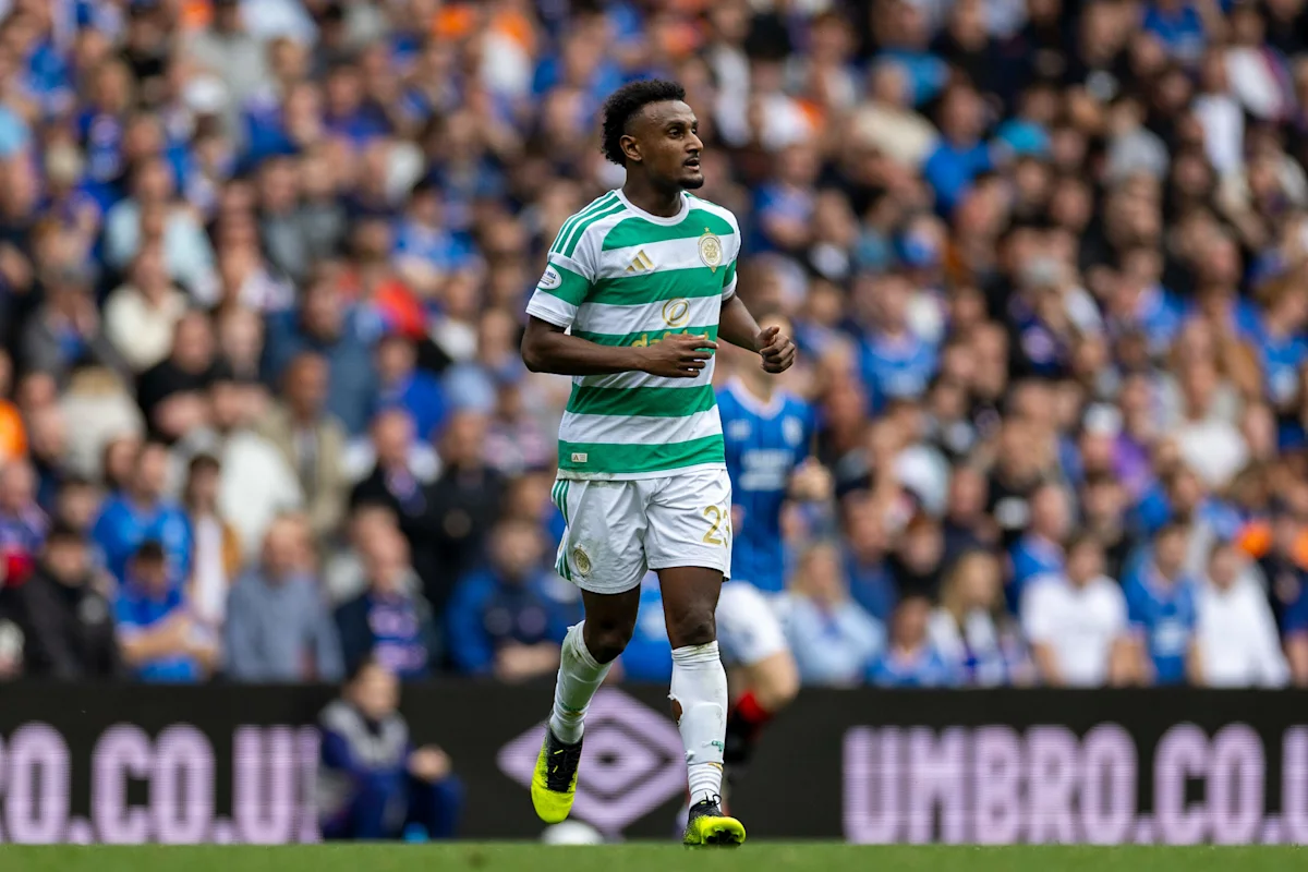 Celtic player in green-and-white hoops runs across the pitch during a football match