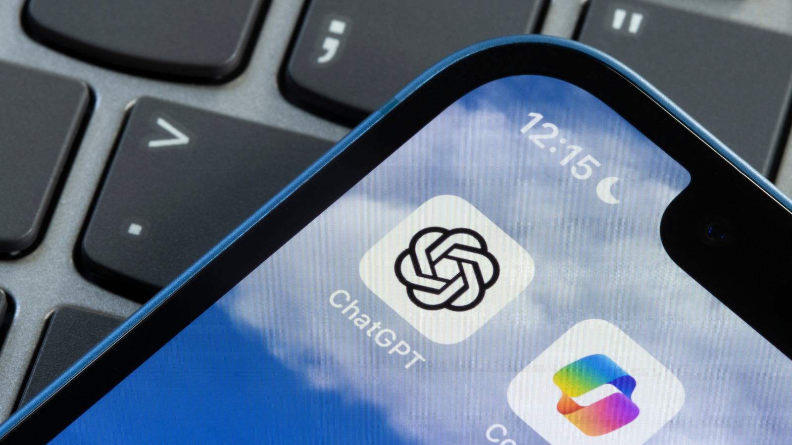 Close-up of a smartphone displaying the ChatGPT logo resting on a computer keyboard