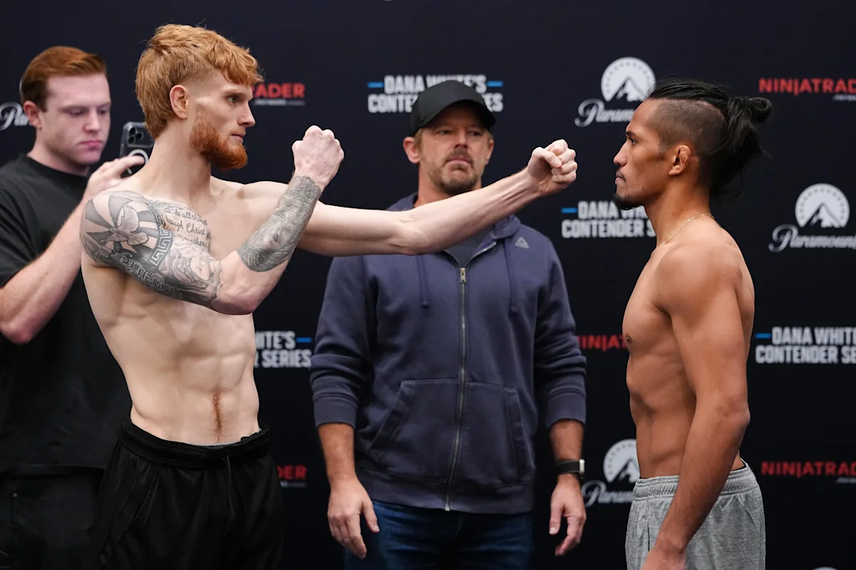 Two shirtless fighters face off with fists raised during a UFC weigh-in event.