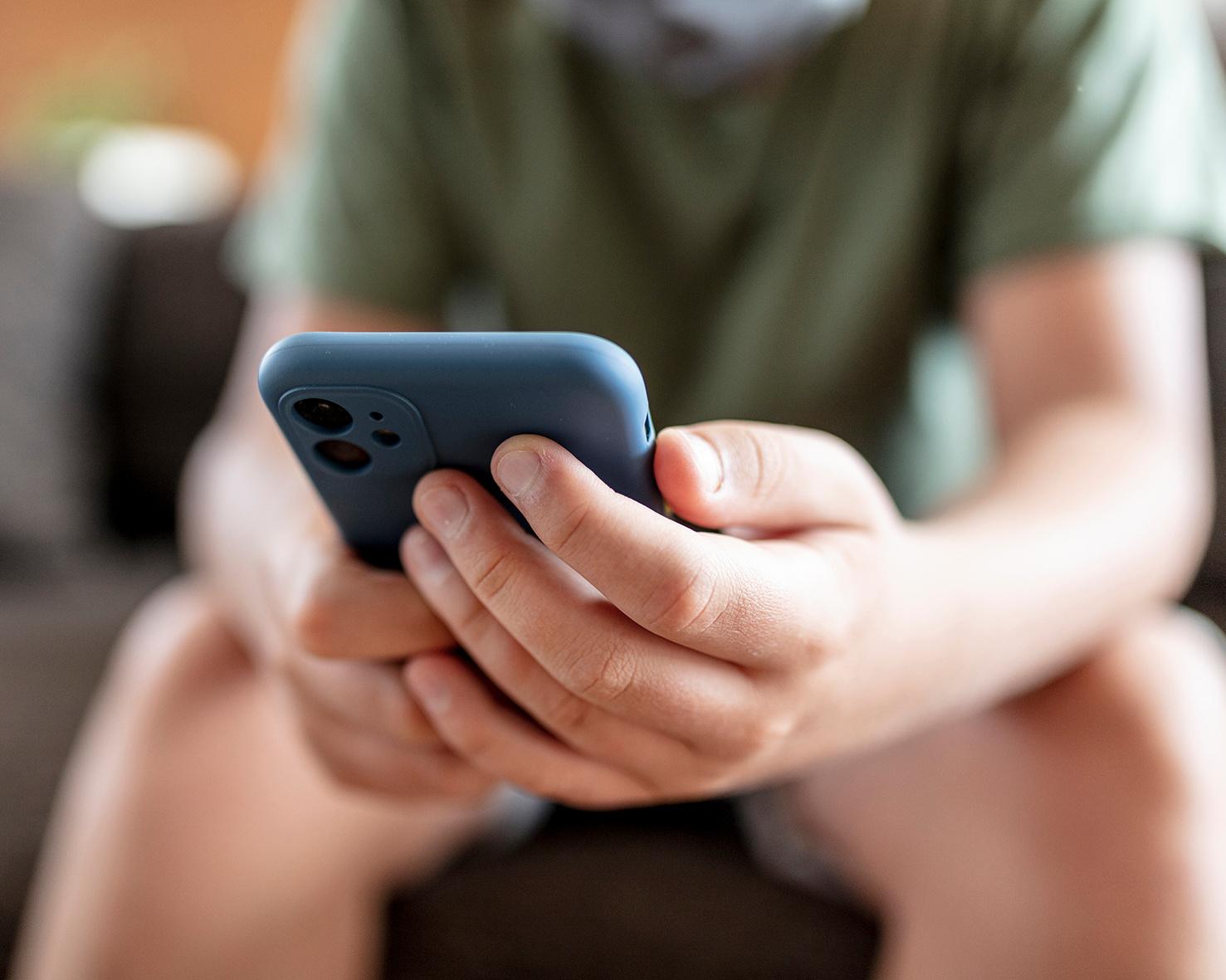 Close-up of a person holding a smartphone with both hands