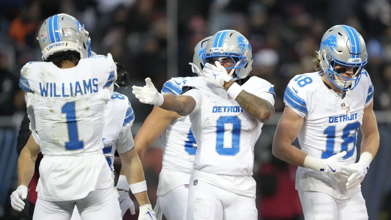 Detroit Lions football players in white uniforms celebrating together during a game