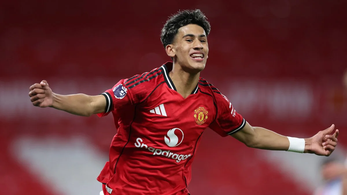 Young footballer in red Manchester United jersey celebrating with arms outstretched