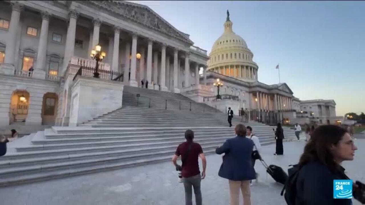 People walk on the steps of the U.S. Capitol beneath its illuminated dome.