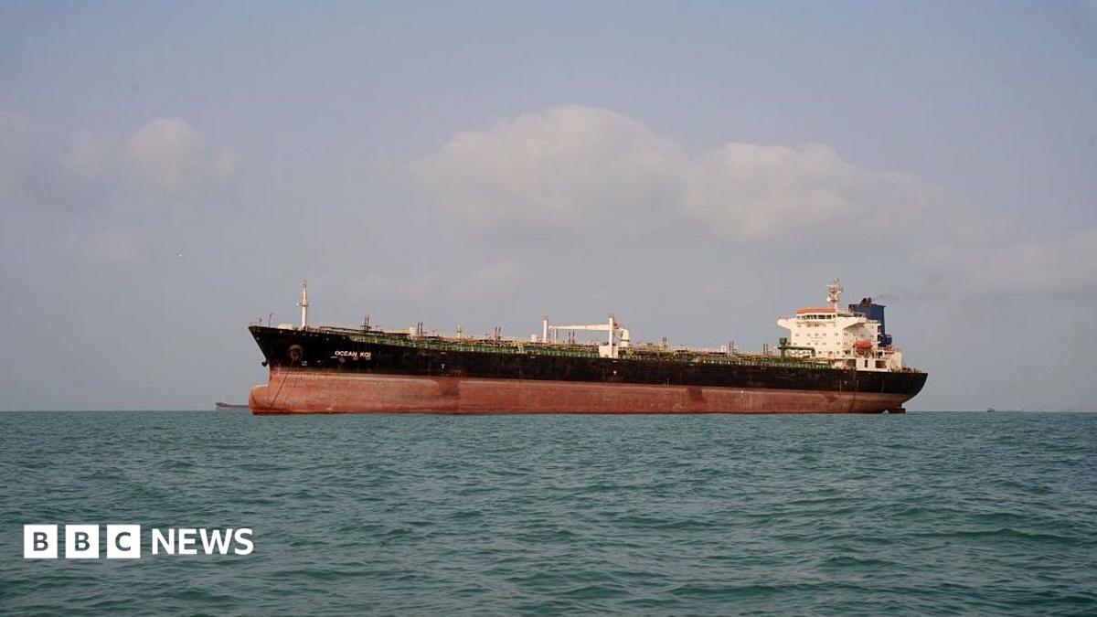 Large commercial tanker sailing across calm sea beneath a cloudy sky