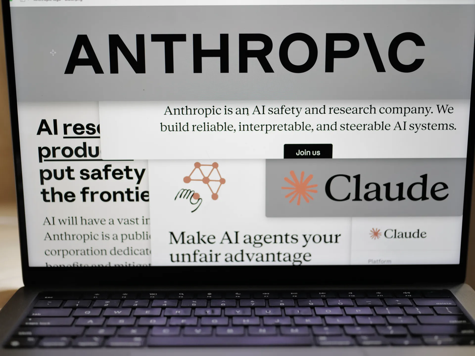 Laptop screen displaying Anthropic and Claude branding alongside AI safety and research text.