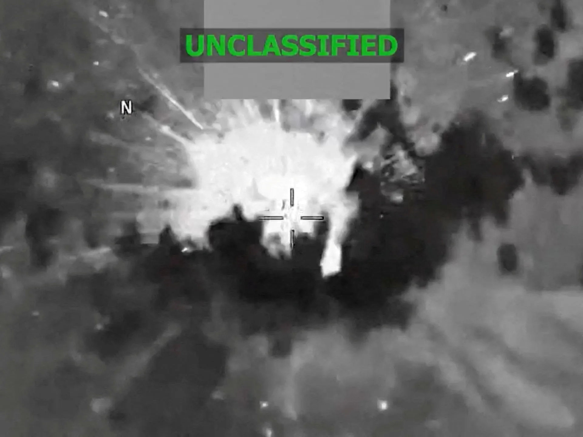 Infrared footage shows a bright explosion amid dark smoke, with targeting crosshairs and an UNCLASSIFIED label.