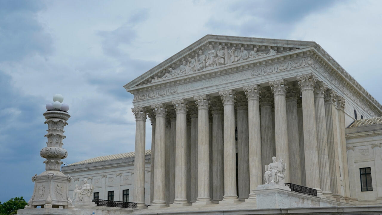 The United States Supreme Court building and its columns beneath a cloudy sky.