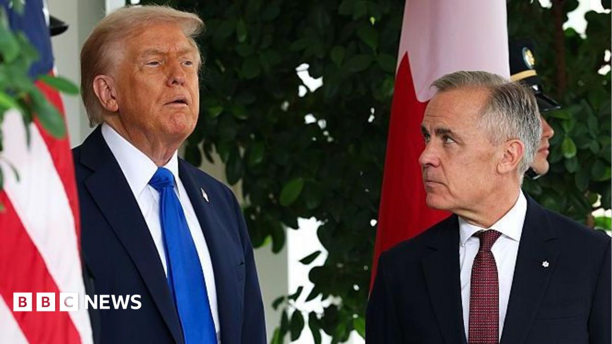 Donald Trump stands beside a Canadian official during a formal outdoor event with national flags.
