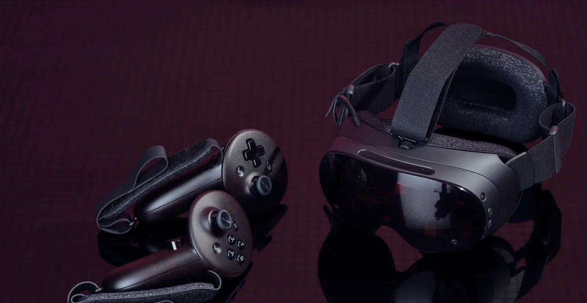 Virtual reality headset and two handheld controllers arranged against a dark burgundy background
