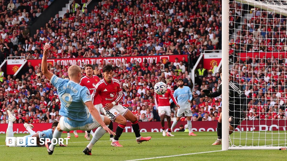 Footballers in red and sky-blue kits contest the ball near goal during a match
