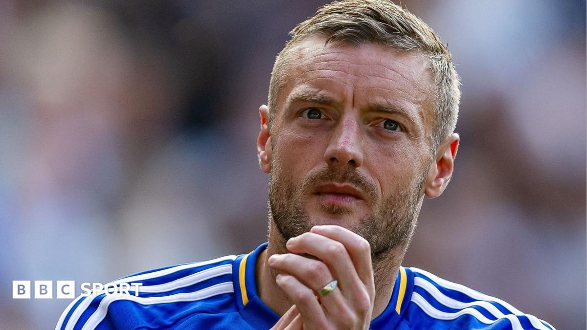 Close-up of a bearded footballer in a blue and white jersey clasping his hands.