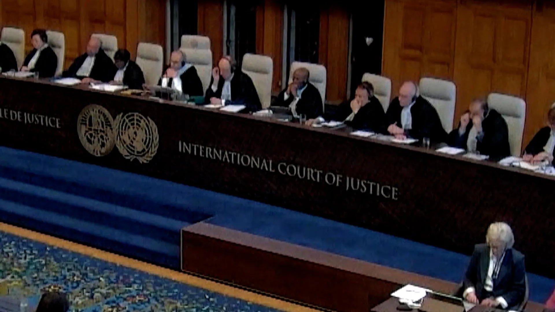 Judges seated behind a bench marked International Court of Justice in a wood-paneled courtroom