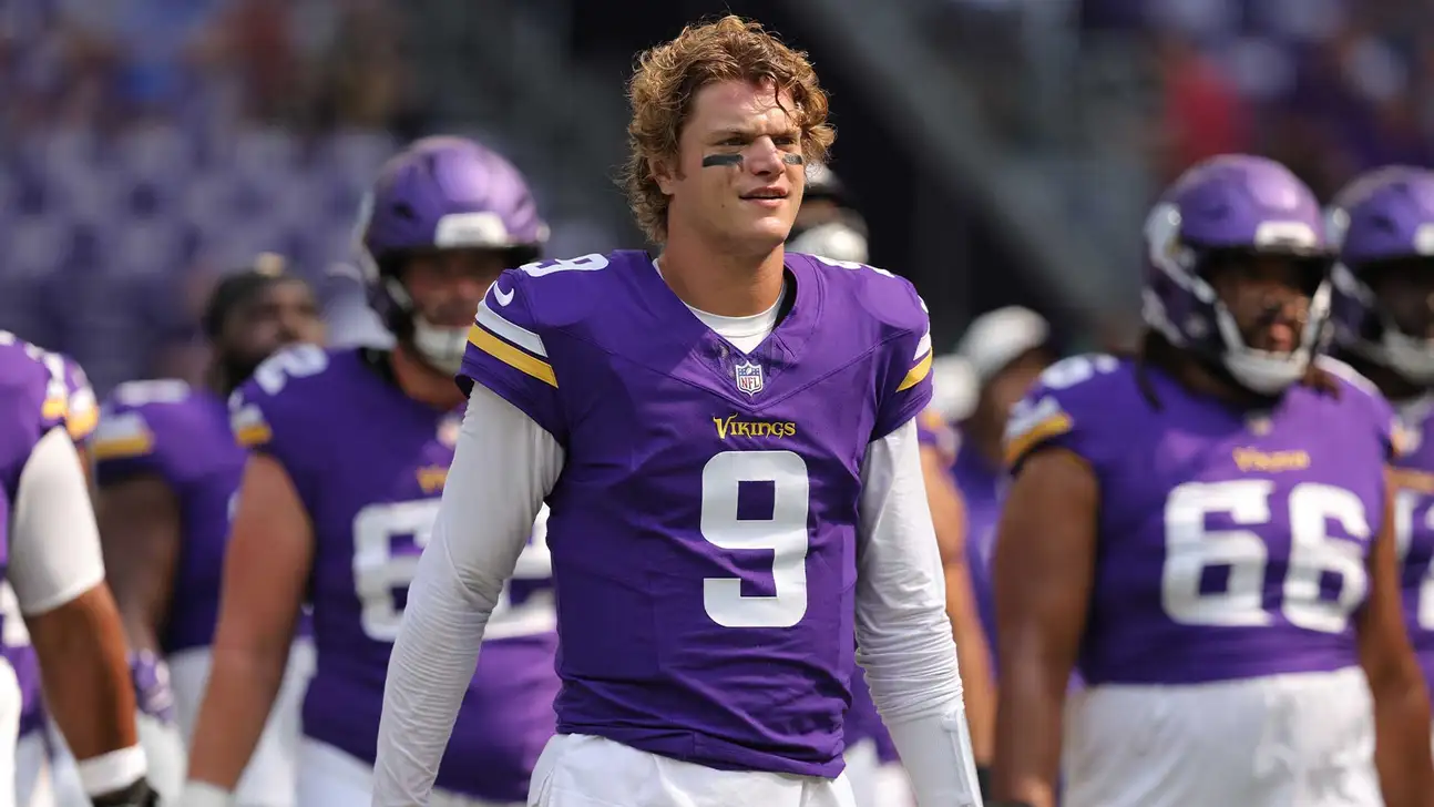Minnesota Vikings quarterback in purple No. 9 jersey standing on field with teammates behind him