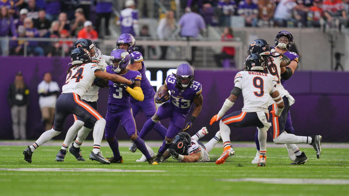 Vikings ball carrier runs through Bears defenders during an NFL game.