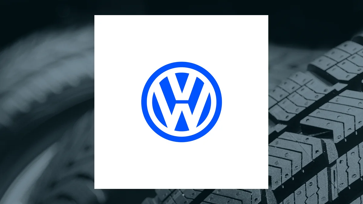 Blue Volkswagen emblem centered on a white panel over a dark tire-and-keyboard background.