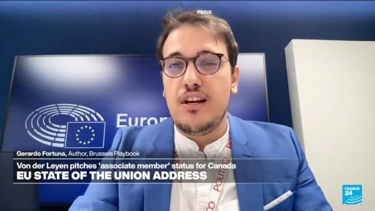 Man wearing glasses and blue jacket speaking during a televised European Parliament segment.