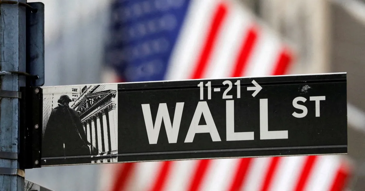 Electronic display reads “11-21 WALL ST” beside a black-and-white image of a person near columns.