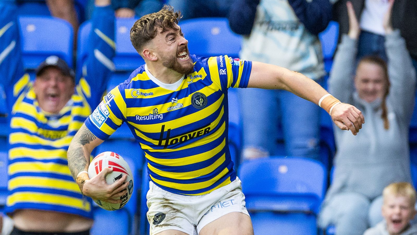 Rugby league player in blue and yellow stripes runs with the ball during a match