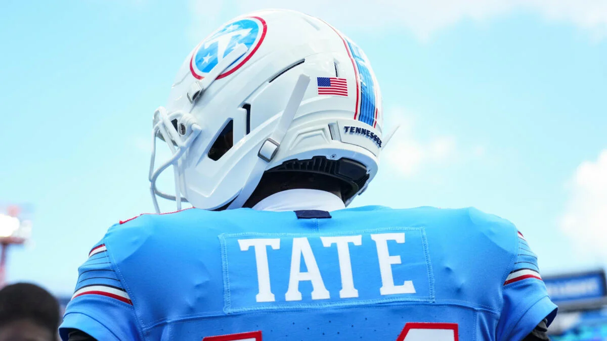 Football player wearing a Tennessee helmet and blue jersey with Tate nameplate viewed from behind