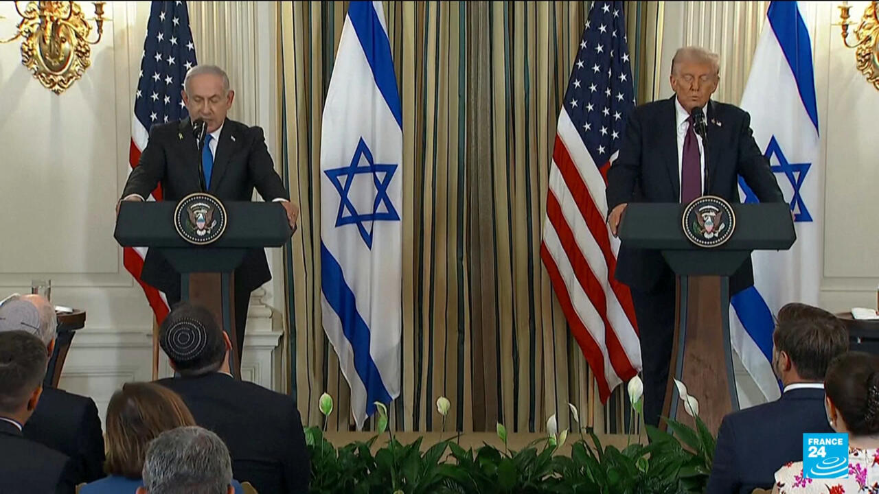 Two officials speak at lecterns flanked by American and Israeli flags during a press event.