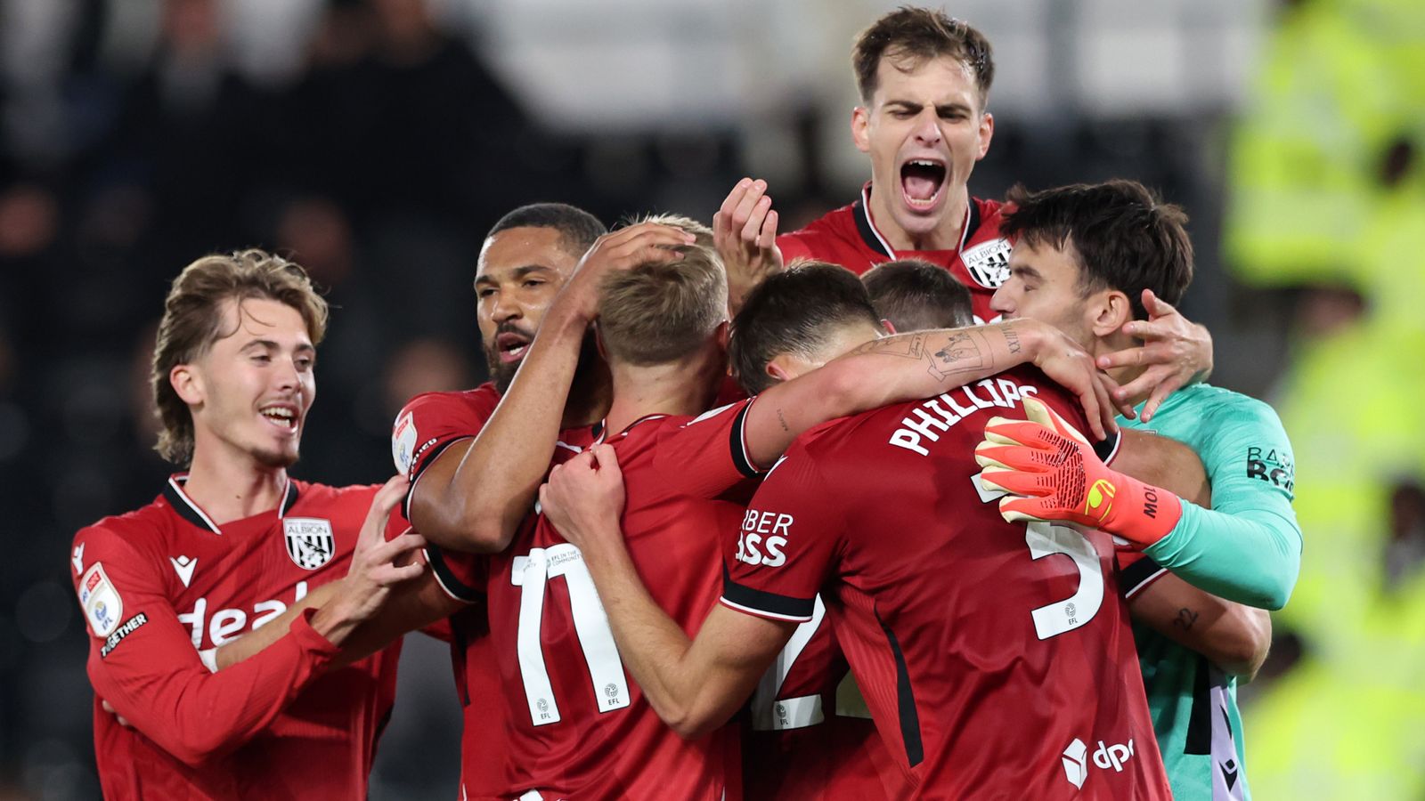 West Bromwich Albion players celebrate together during a football match, with goalkeeper joining the group