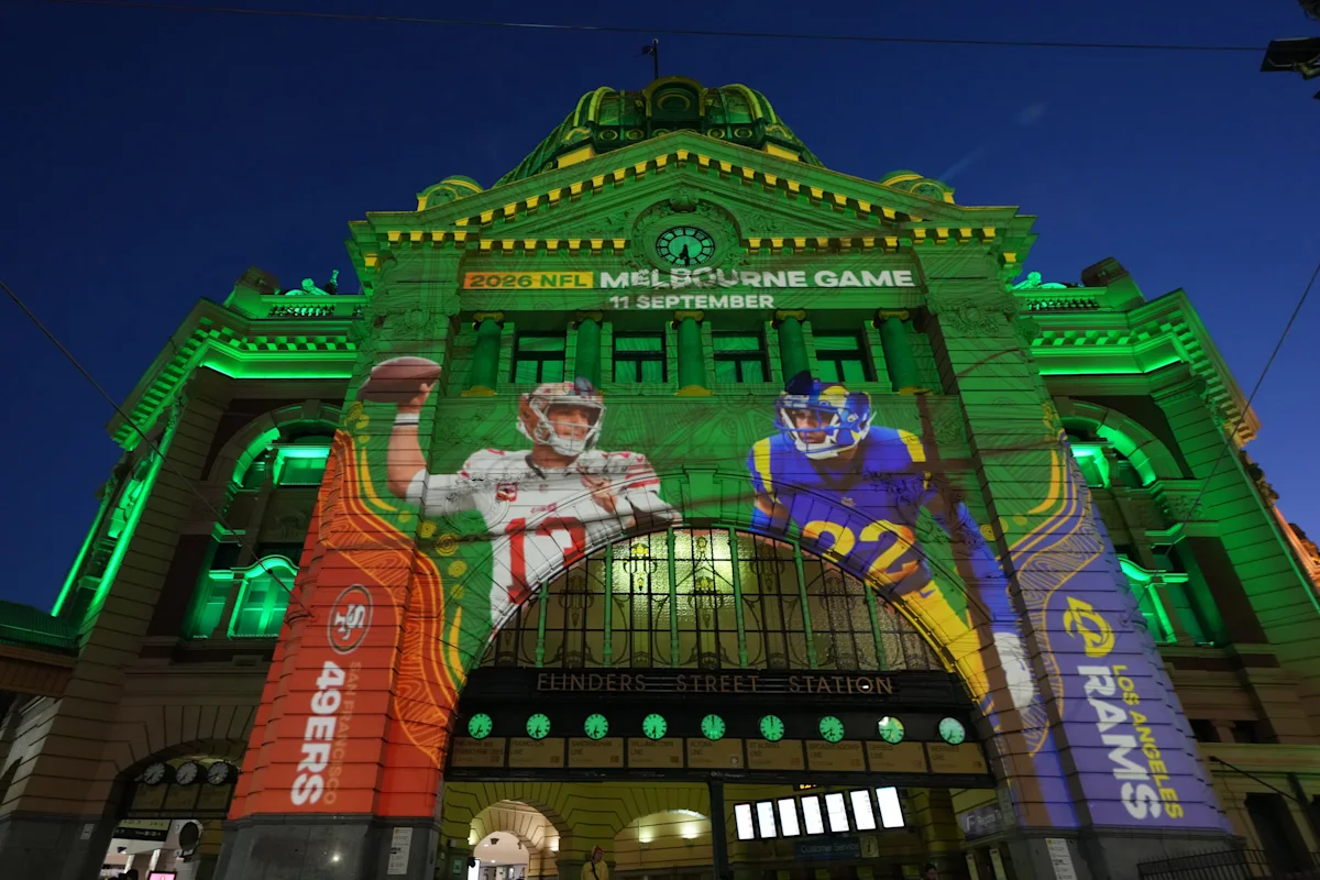 Illuminated station facade displays projected San Francisco 49ers and Los Angeles Rams players