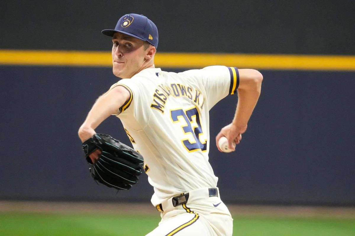 Milwaukee Brewers pitcher in uniform winds up to throw a baseball during a game