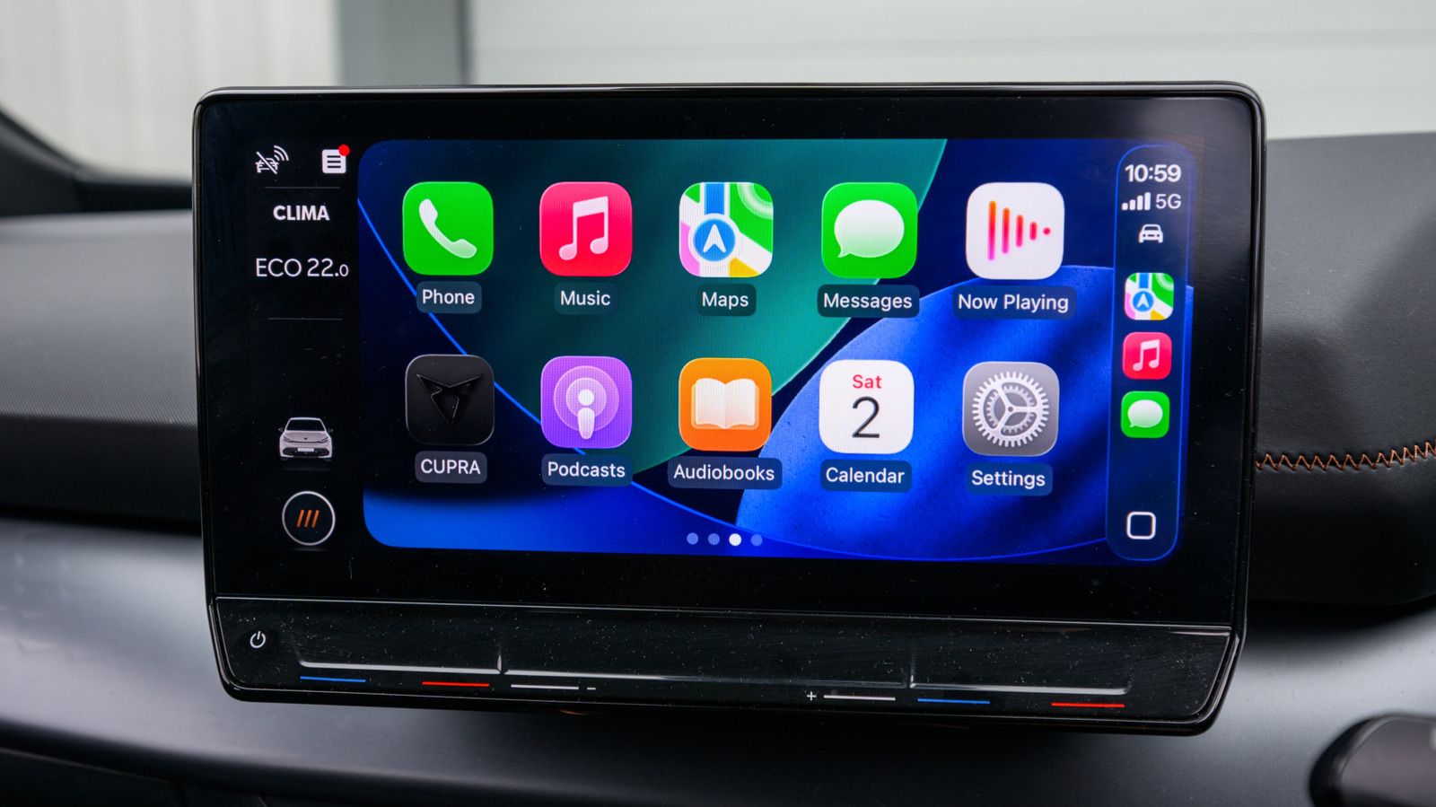 Car dashboard touchscreen displaying Apple CarPlay apps, including Phone, Music, Maps, Messages and Settings.