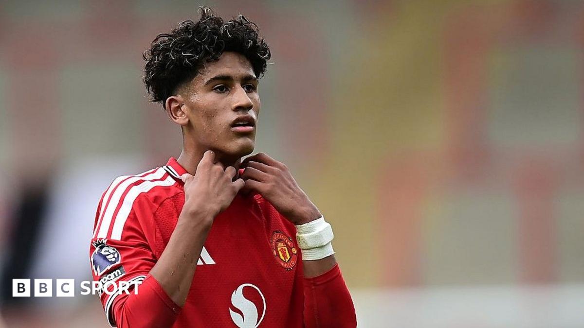 Footballer in red Manchester United shirt adjusting his collar during a match