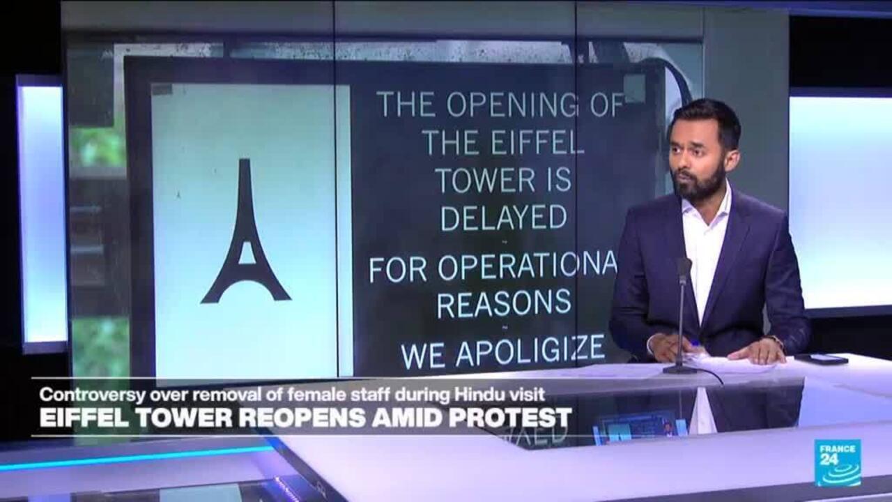 News presenter stands beside a broadcast graphic showing an Eiffel Tower symbol and delayed opening notice.