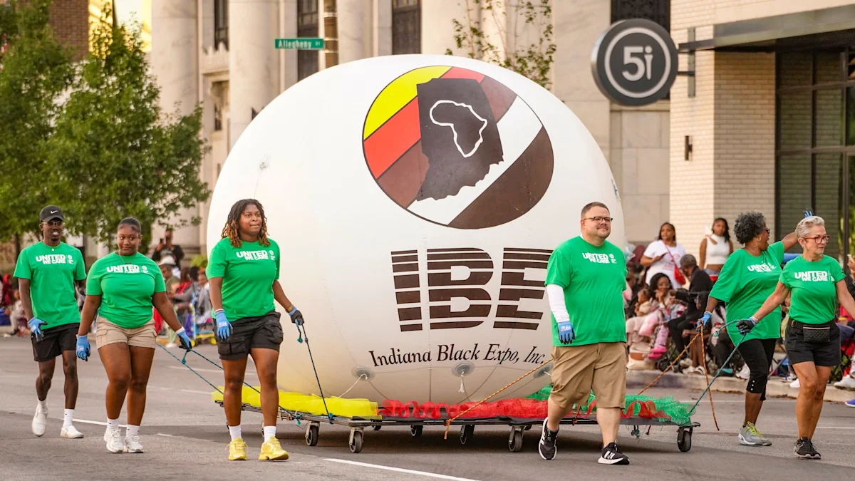 Volunteers in green shirts pull a large white parade float past spectators on a city street.