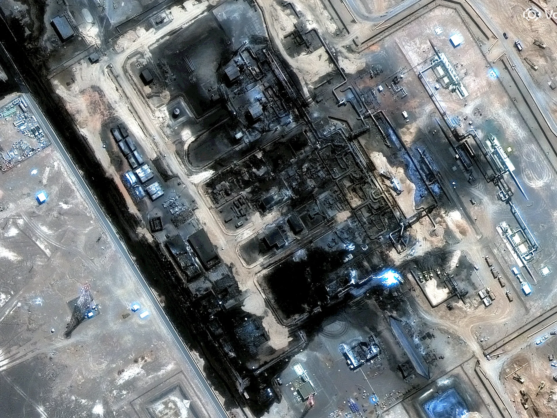Aerial view of a sprawling industrial facility with pipelines, processing structures, roads and storage areas