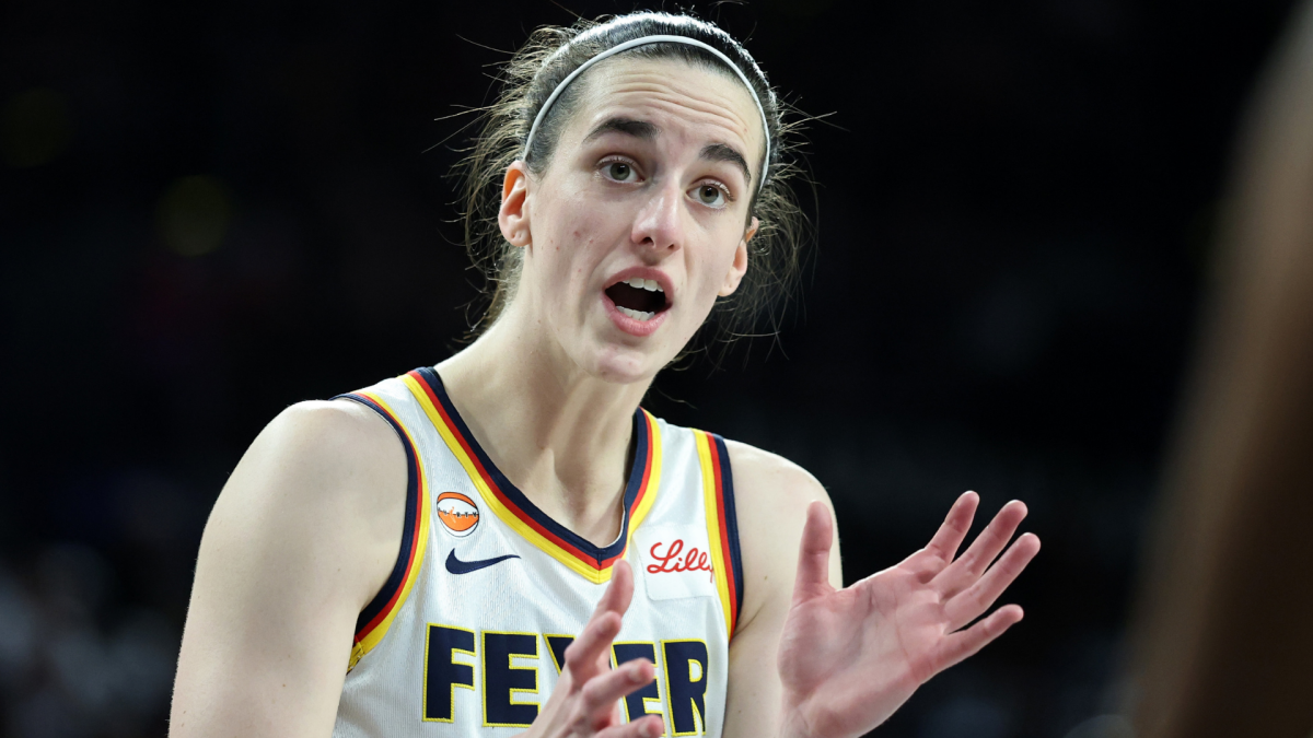Basketball player in a white Fever jersey gestures with both hands during a game.