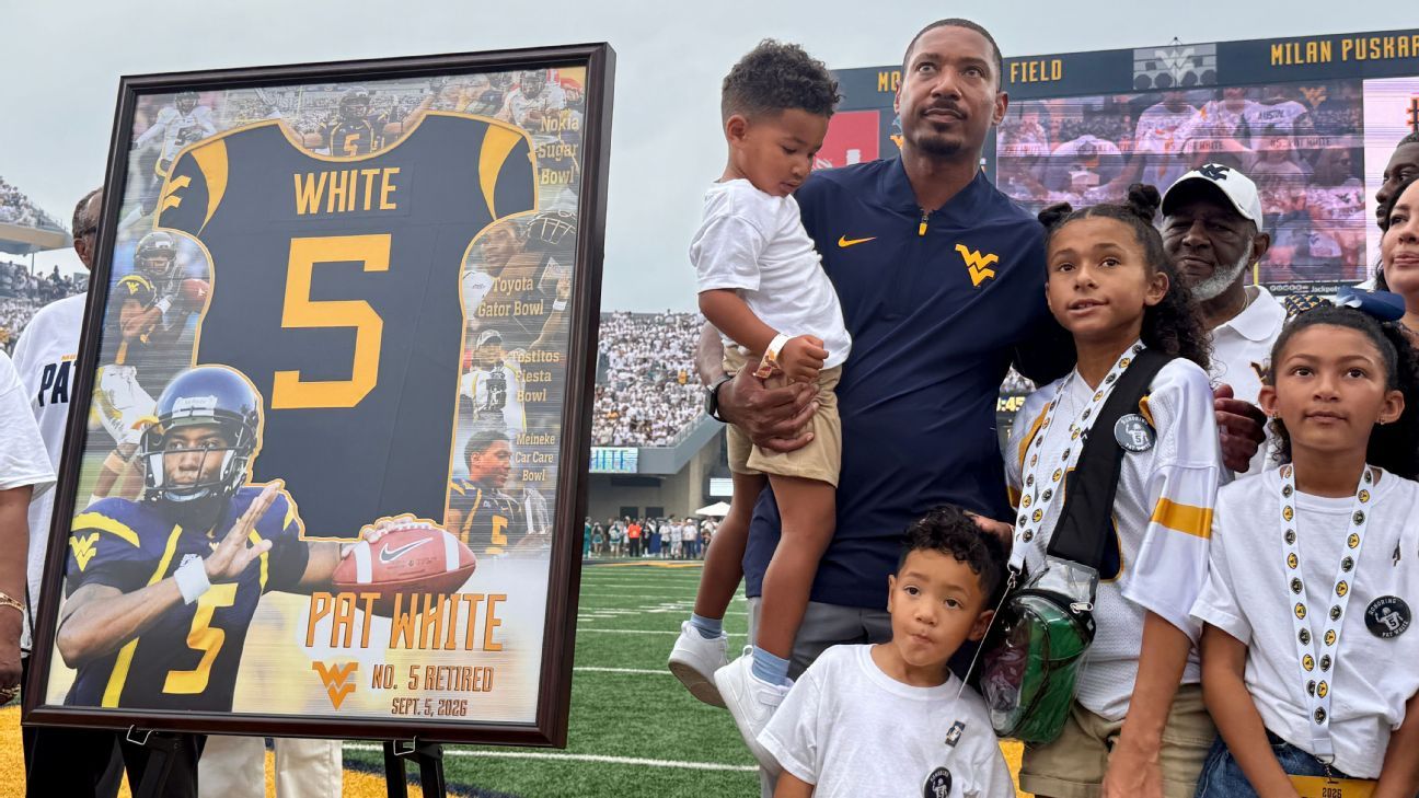 Framed No. 5 Pat White jersey displayed beside a man and children at a football stadium.