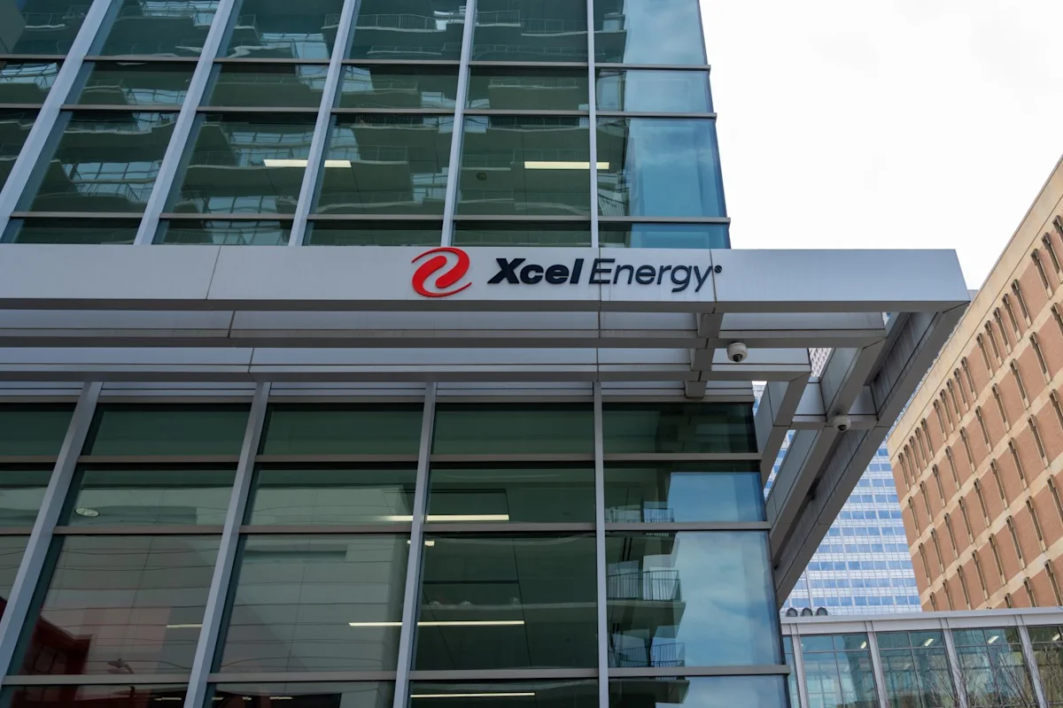 Xcel Energy logo displayed on the facade of a modern glass office building.