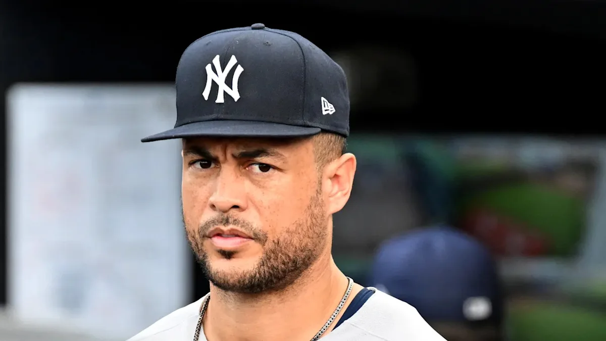 Baseball player wearing a black Yankees cap and white shirt during a game