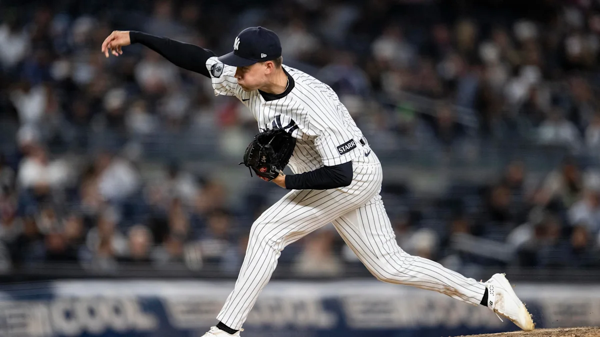Yankees pitcher in pinstripes winds up on the mound during a game.