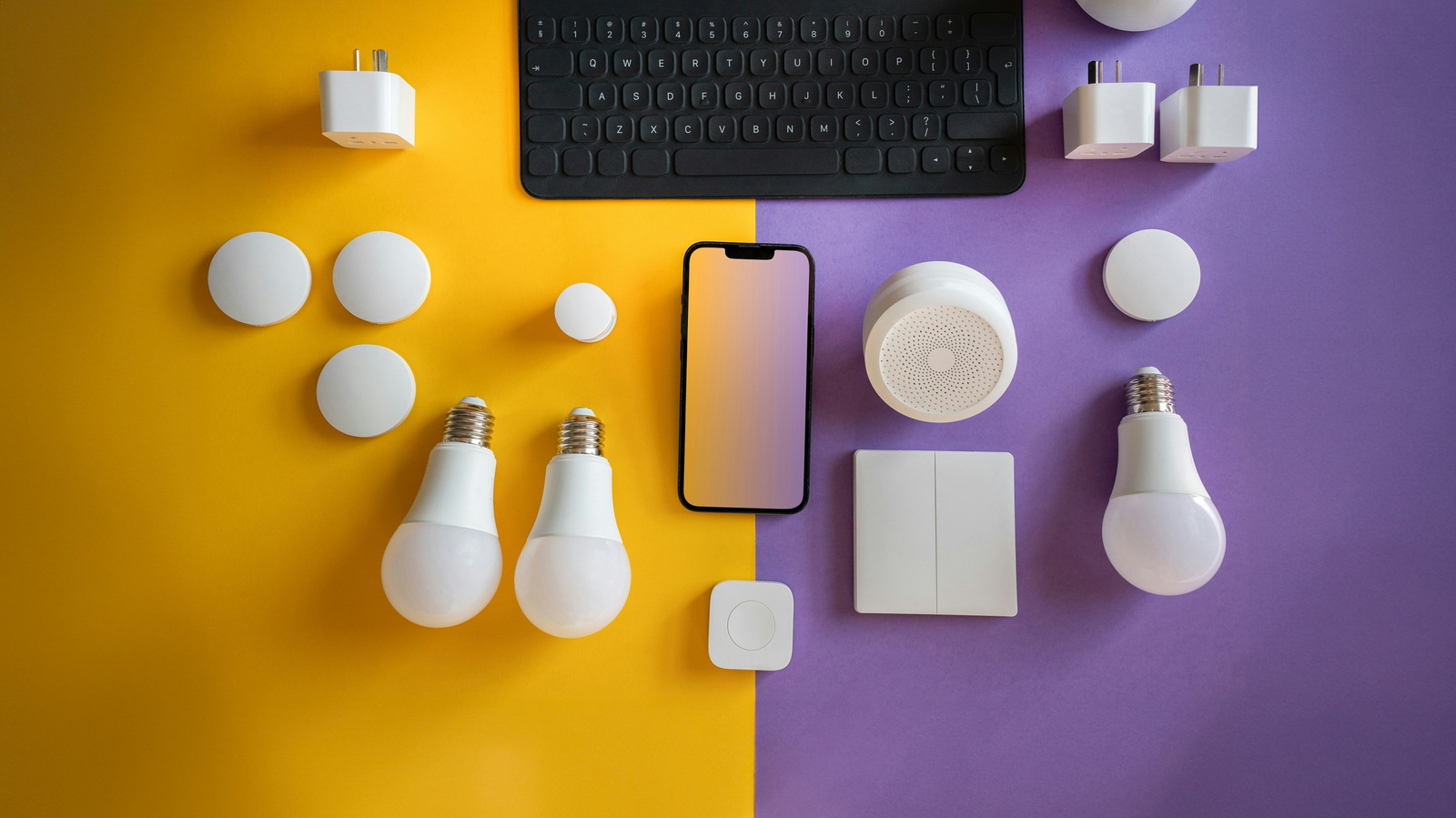 Smart home devices, bulbs, switches, a smartphone, and keyboard arranged on yellow and purple surfaces.