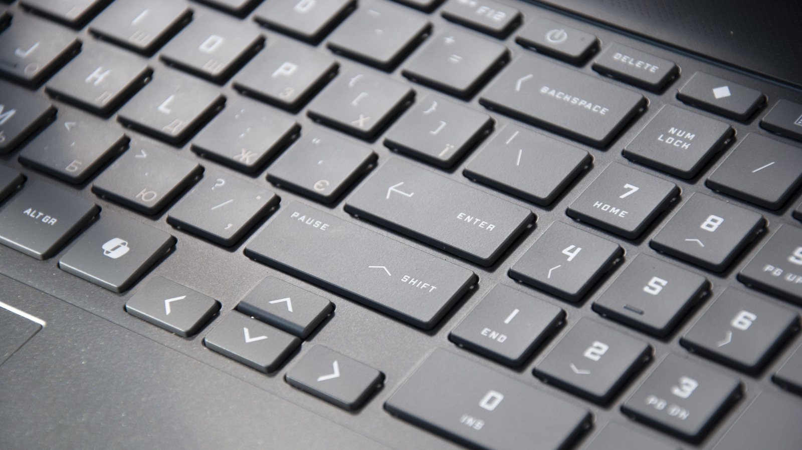 Close-up of a gray laptop keyboard showing Enter, Shift, navigation, number, and symbol keys