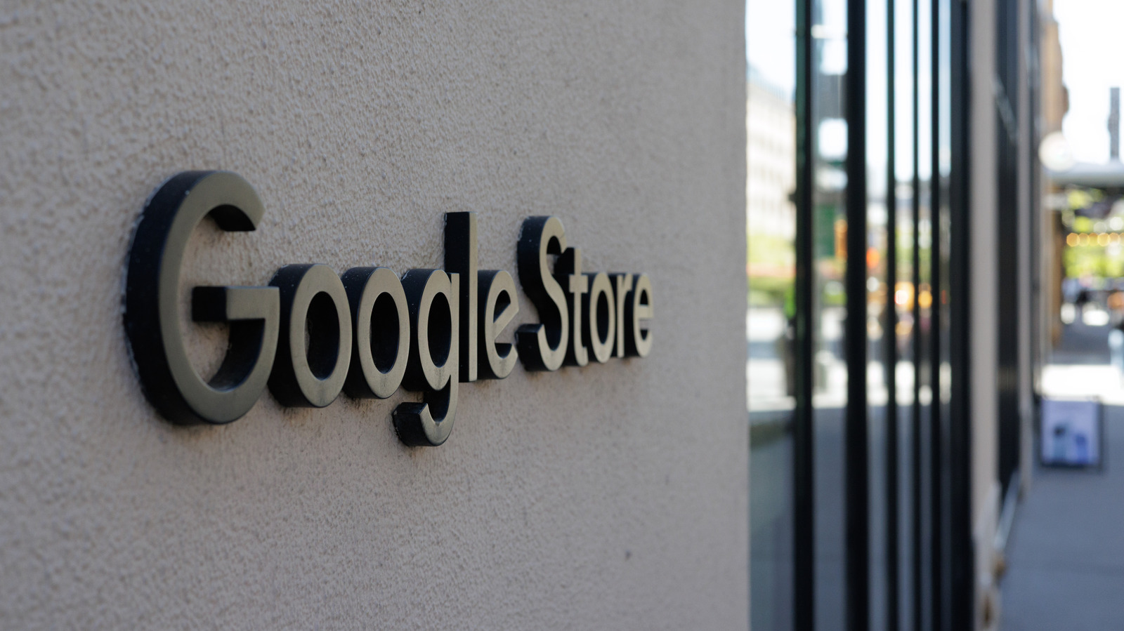 Google Store sign mounted on a textured exterior wall beside tall storefront windows
