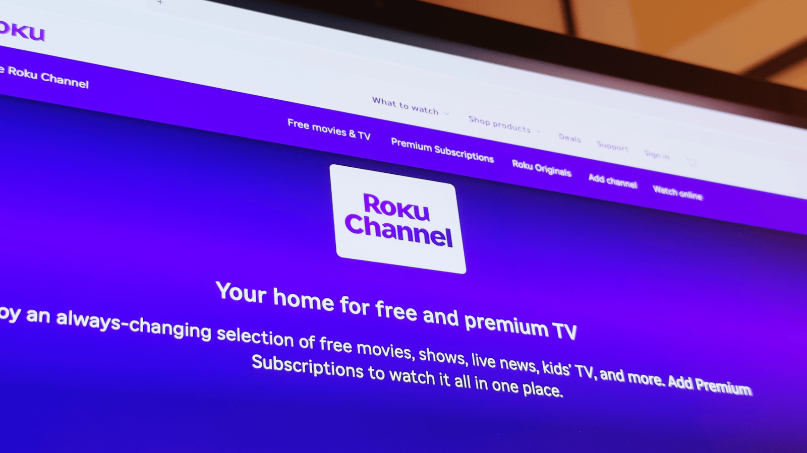 A tilted photograph shows the Roku Channel website promoting free movies, television, and premium subscriptions.
