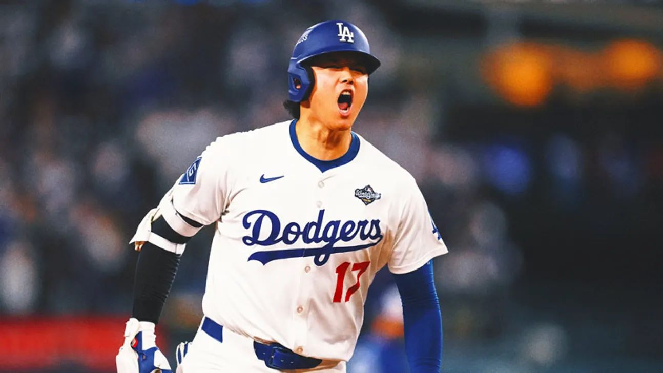 A Dodgers player in a white number 17 jersey and blue helmet shouts on the field.