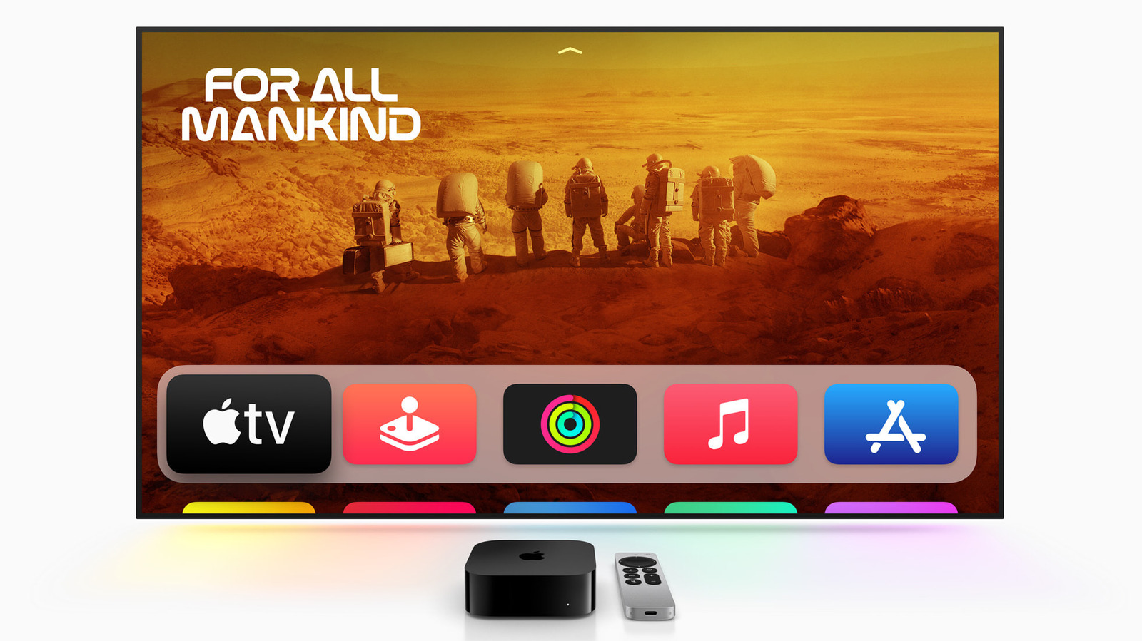 A television displays For All Mankind above a row of Apple service icons, with a streaming box and remote below.