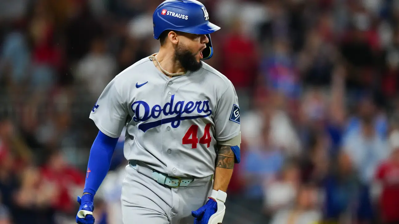 Dodgers player in a gray number 44 uniform and blue helmet reacts on the field.