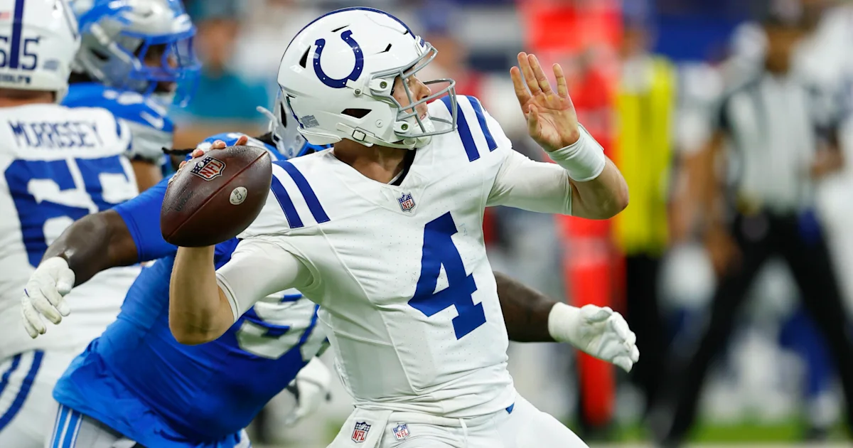 Indianapolis Colts quarterback in a white number 4 jersey throws a football as a defender closes in.