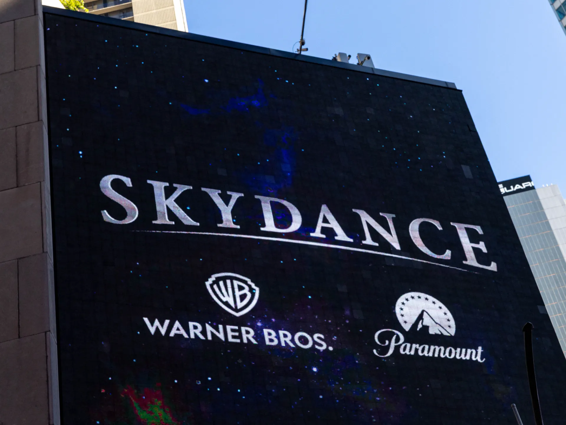 A large outdoor screen displays the Skydance, Warner Bros., and Paramount logos against a starry background.