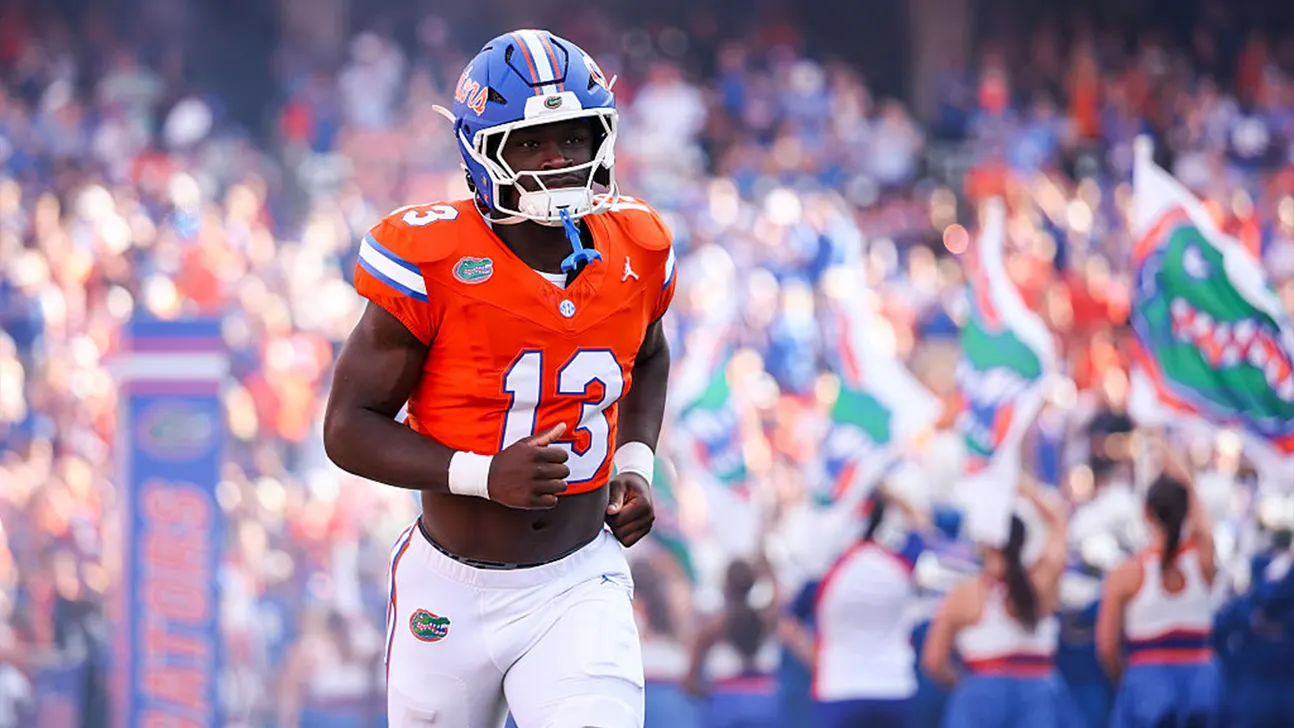 Florida Gators player wearing number 13 runs on the field in an orange jersey and blue helmet.